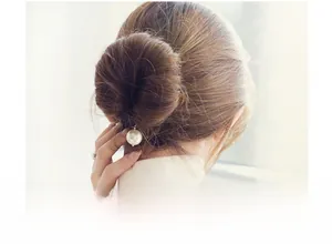Detailed view of elegant pearl hair styling tool for bun hairstyles on a model