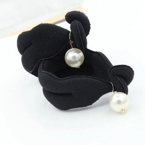 Close-up of a black velvet hair bun maker with elegant white pearl charms and gold accents
