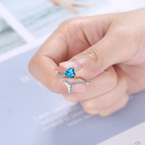Adjustable silver ring featuring a blue heart gemstone and sparkling pavé fish tail