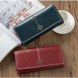 Close-up of vintage long wallets with contrast stitching and clover metal buckle detail