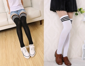 Detail of striped over-the-knee socks in black and white colors with knit texture