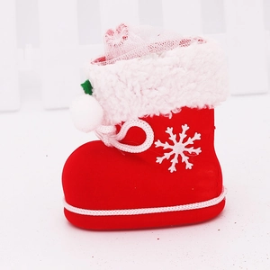 Close-up of red flocked Christmas boot candy bag with white fur trim and snowflake