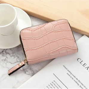Pink crocodile texture card holder with metal zipper detail on marble surface backdrop
