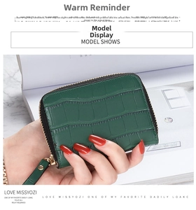 Close-up of a dark green crocodile texture mini card holder with gold zipper detail