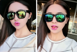 Close-up of black oversized sunglasses with reflective green-yellow polarized lenses