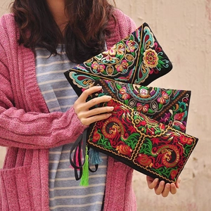 Detailed view of ethnic embroidered clutch bags featuring intricate floral patterns and tassels