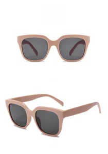 Detailed view of rectangle pink sunglasses with gray lenses and metal rivet accents