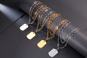 Detail of double-layer gold and silver paperclip necklaces with square pendant tags