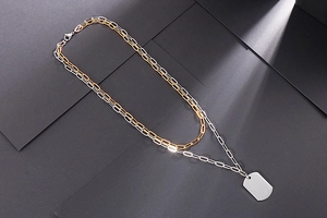 Detail view of double layer gold and silver paperclip chain with rectangular tag pendant