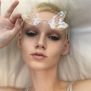 Close-up of clear butterfly wing rimless sunglasses featuring delicate resin vein details