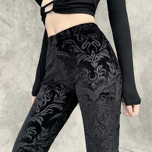 Detail of gothic damask velvet texture on black high-waisted flared trousers
