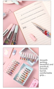 Detail of lipstick shaped rollerball pens with colorful beads and pastel macaron caps
