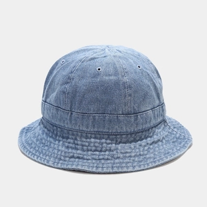 Gros plan d'un bob en jean bleu clair montrant la texture du tissu et les œillets