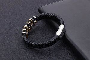 Detailed view of black woven leather bracelet with silver magnetic clasp and metal trim