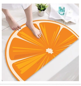 Detail showing high-absorbent semi-circle orange slice bath mat on white tiles
