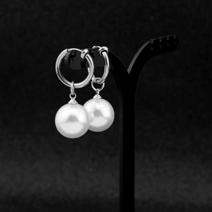 Detailed view of silver stainless steel hoop earrings with glossy white round pearls