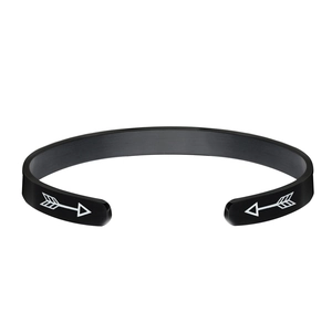 Close-up of black matte titanium steel open C-shaped bracelet with white arrow patterns
