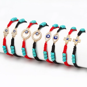 Detailed view of woven bracelets with evil eye charms and turquoise beads set