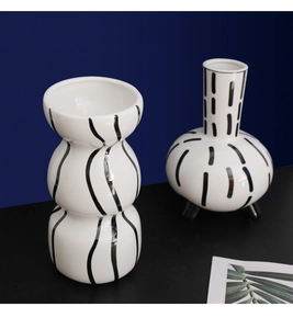 Modern white ceramic vases with black stripes in a stacked sphere and tripod shape