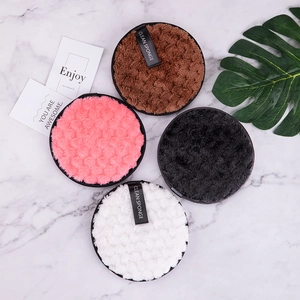 Close-up of four soft reusable microfiber makeup remover pads on marble surface