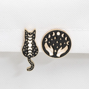 Enamel pins set featuring black cat silhouette and hands holding lunar phases designs