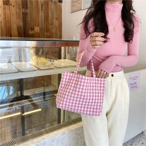 Pink vichy plaid cotton linen handbag shown in a lifestyle bakery setting