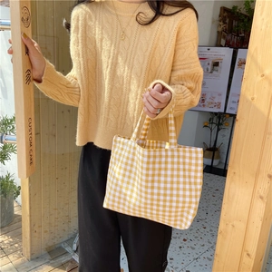 Detailed close-up of yellow and white gingham cotton canvas tote bag held by model