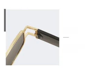 Close-up of golden metal hinges and black temples on irregular vintage sunglasses