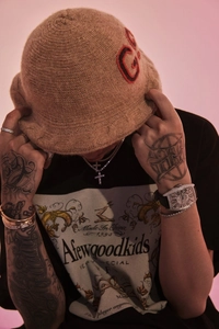 Close-up of Afewgoodkids cross necklace and watch styled with a printed graphic t-shirt