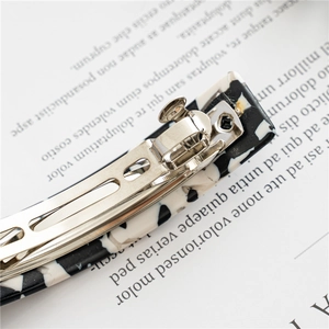 Elegant tortoiseshell acetate spring hair clip with black and white marble pattern