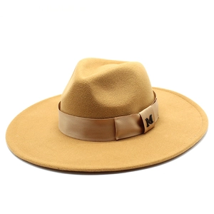 Detail of camel wool fedora hat featuring a wide brim and metallic M letter logo