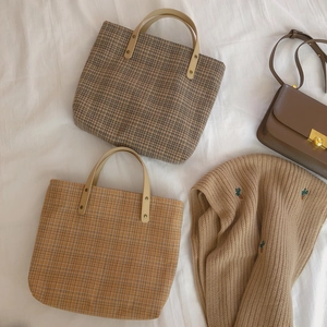 Vintage checkered tote bag with leather handles in warm brown and gray plaid patterns