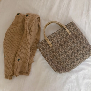 Flat lay of vintage plaid tote bag with faux leather handles and knit cactus cardigan