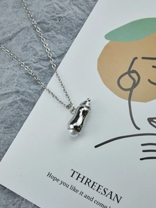 Vue détaillée du pendentif cacahuète en argent avec perle sur une chaîne délicate