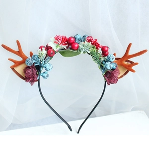 Christmas reindeer antler headband with silk roses and colorful berries on white background