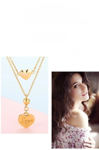 Détail du collier double couche doré avec pendentif en cœur et gravure Love