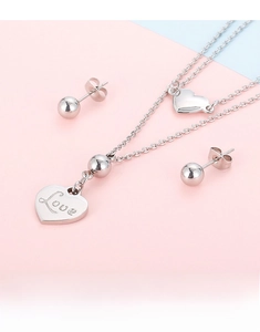 Gros plan du collier cœur argenté avec gravure Love et boucles d'oreilles assorties