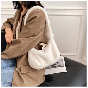 Detail of soft cream faux fur hobo bag with beige ribbon bow shown on a shoulder