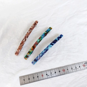 Macro detail showing 10cm acetate hair clips with tortoiseshell patterns and metal springs