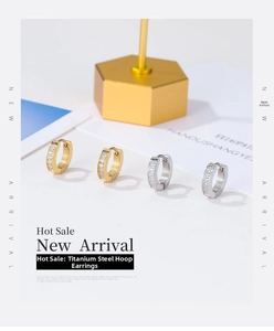 Detail view of titanium steel hoop earrings with white zircon in gold and silver finish