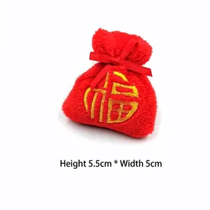 Détail du petit sac de chance en peluche rouge avec broderie dorée, 5,5cm sur 5cm