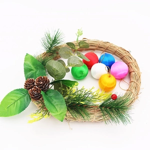 Handcrafted Christmas wreath with colorful ornaments, pine cones, and greenery on white