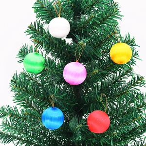 Detail of colorful silk thread Christmas ball ornaments hanging on a tree with gold strings