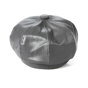 Macro detail of dark grey faux leather newsboy cap showing stitching and classic texture