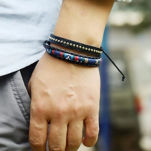 Close-up of multilayer leather bracelet with gold studs and colorful woven ethnic patterns