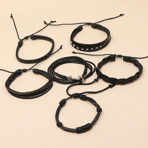 Detail view of 5-piece black leather bracelet set featuring anchor charms and braided ropes