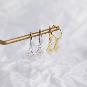 Close-up of S925 sterling silver rhombus earrings with sparkling starburst zircon details
