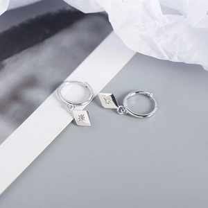 Detailed macro view of S925 silver hoop earrings with rhombus star pendants and cubic zirconia