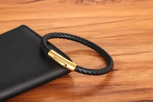 Close-up of black braided leather bracelet with golden magnetic clasp on leather case