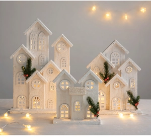 Detalle de cabañas de madera navideñas luminosas con purpurina de nieve y luces LED